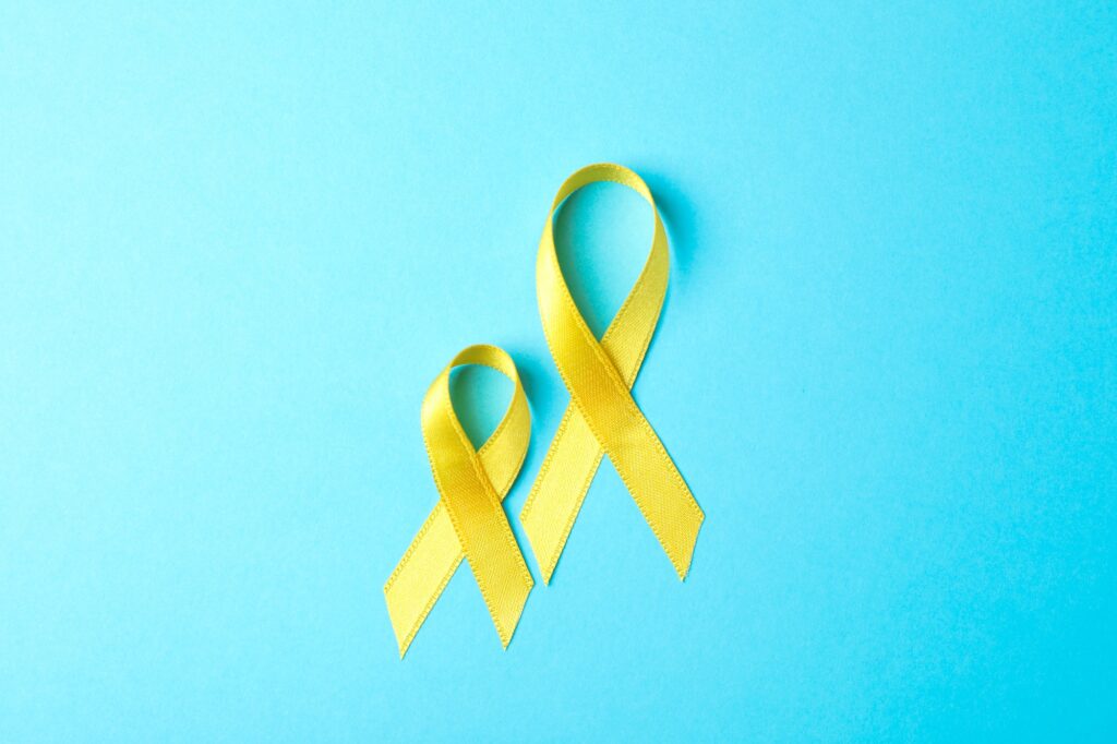 Yellow awareness ribbons on blue background, space for text.